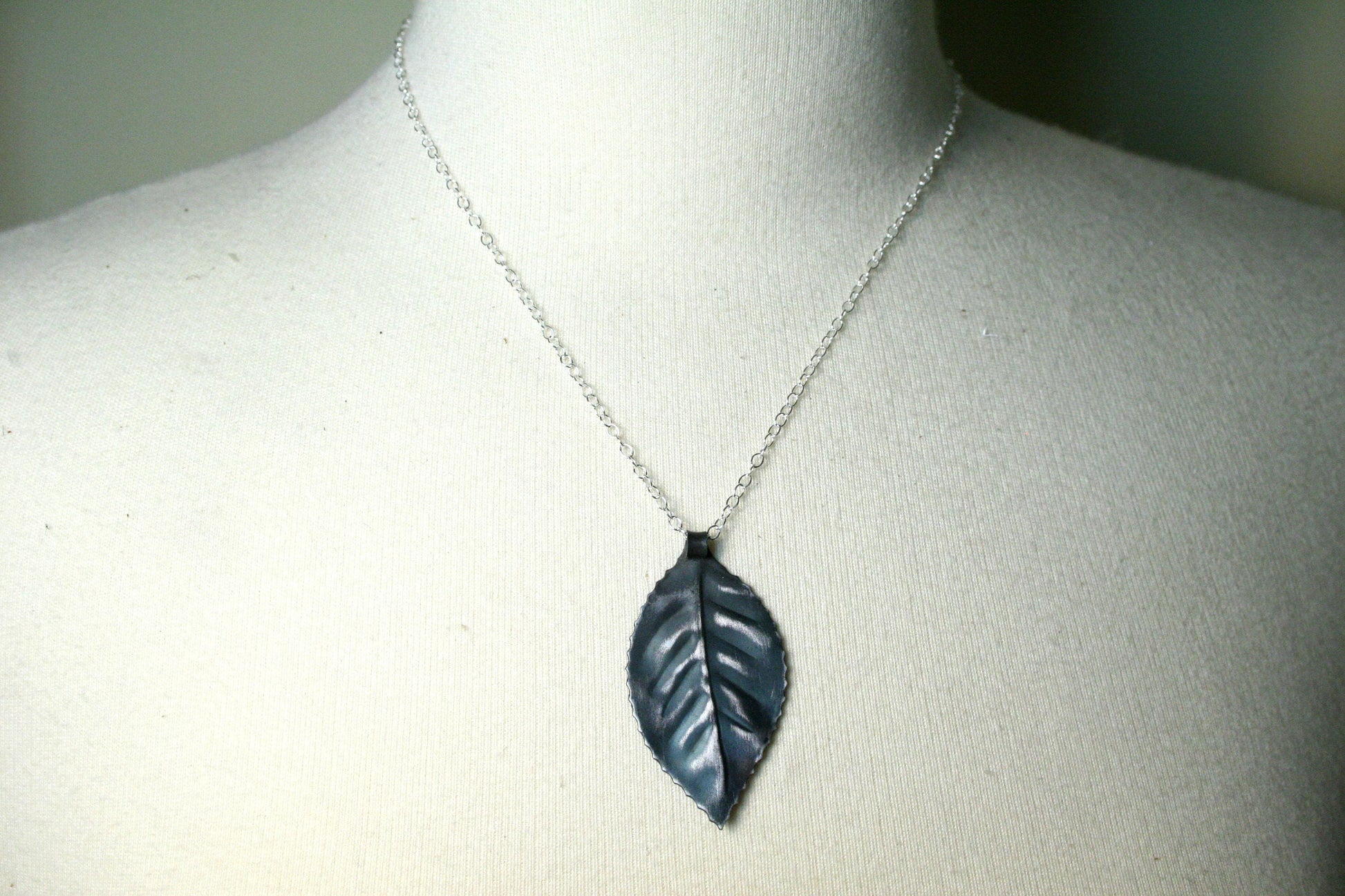 Iron leaf pendant hung from sterling silver chain