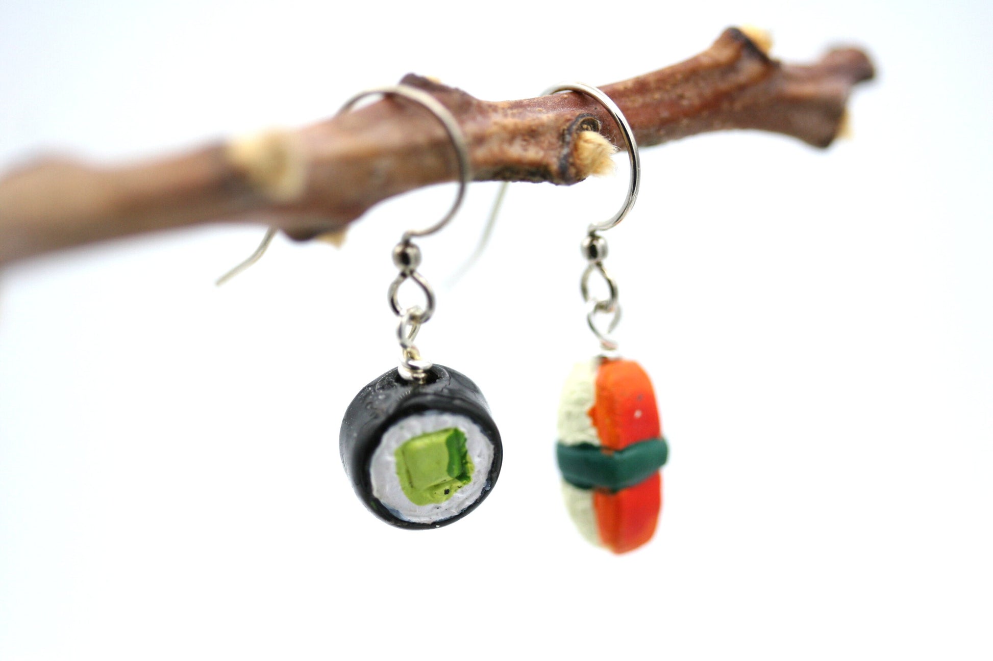These are tiny, hand painted clay, sushi earrings. Guaranteed to start a conversation and get noticed.

These are hung from stainless steel ear wires and measure 1 inch from the top of the ear wire to the bottom. You will receive one maki hand roll earring for one ear and one Nigiri sushi piece for the other.
