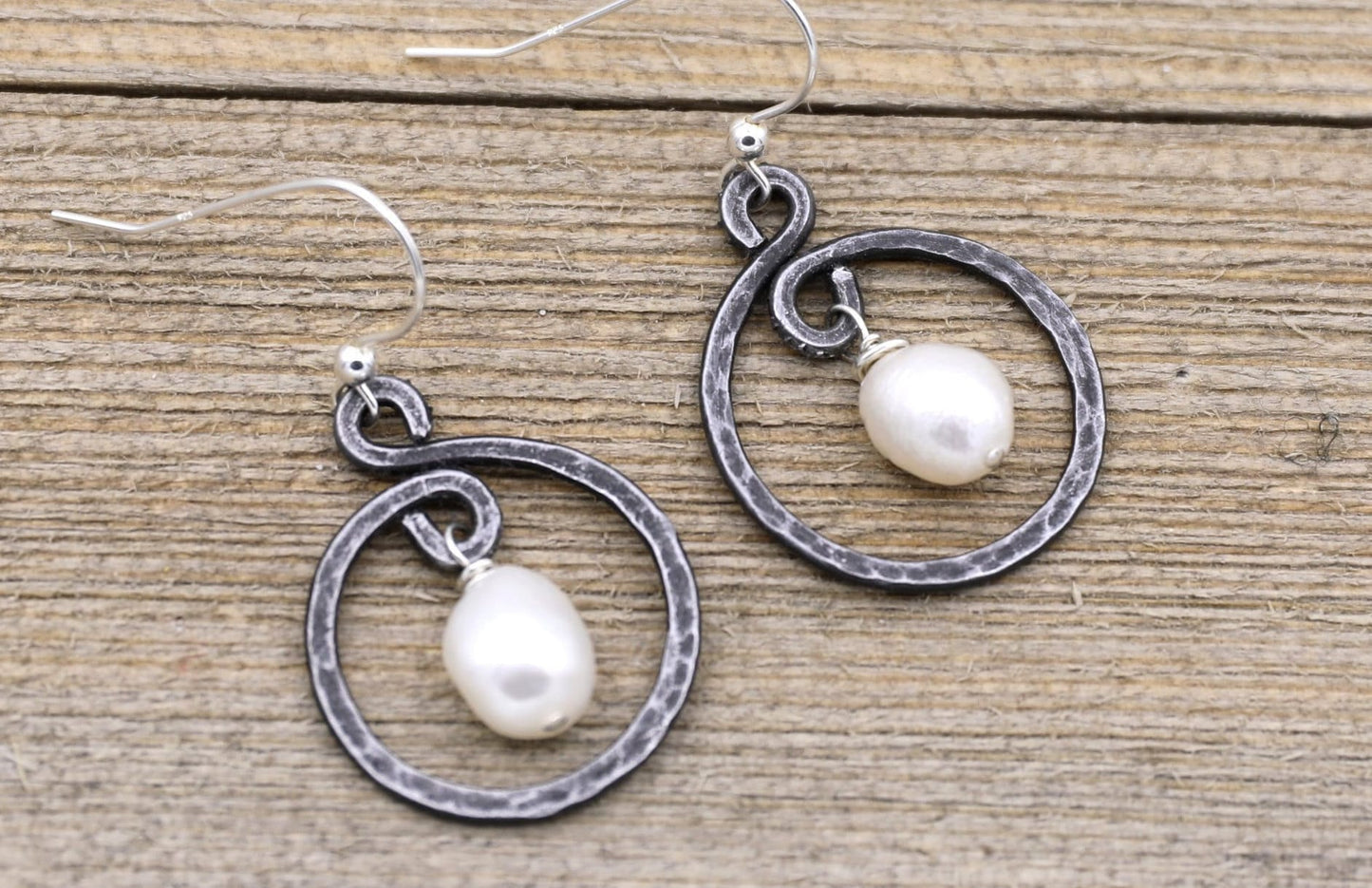 iron hoop earrings with white pearl in the center