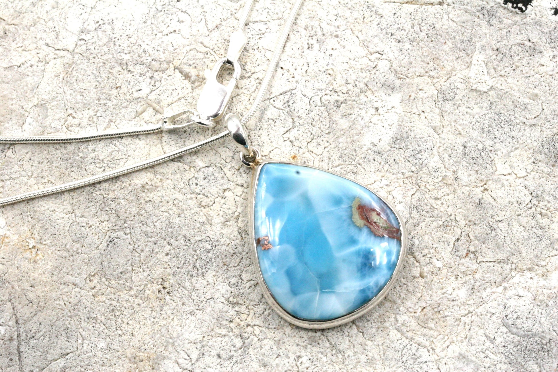 Beautiful, AAA quality Larimar necklace set in solid sterling silver.

The stone measures 1 inch tall X 7/8 inch wide.

Hung from a solid sterling silver, snake chain, you can choose from either 16, 18 or 20 inch lengths.