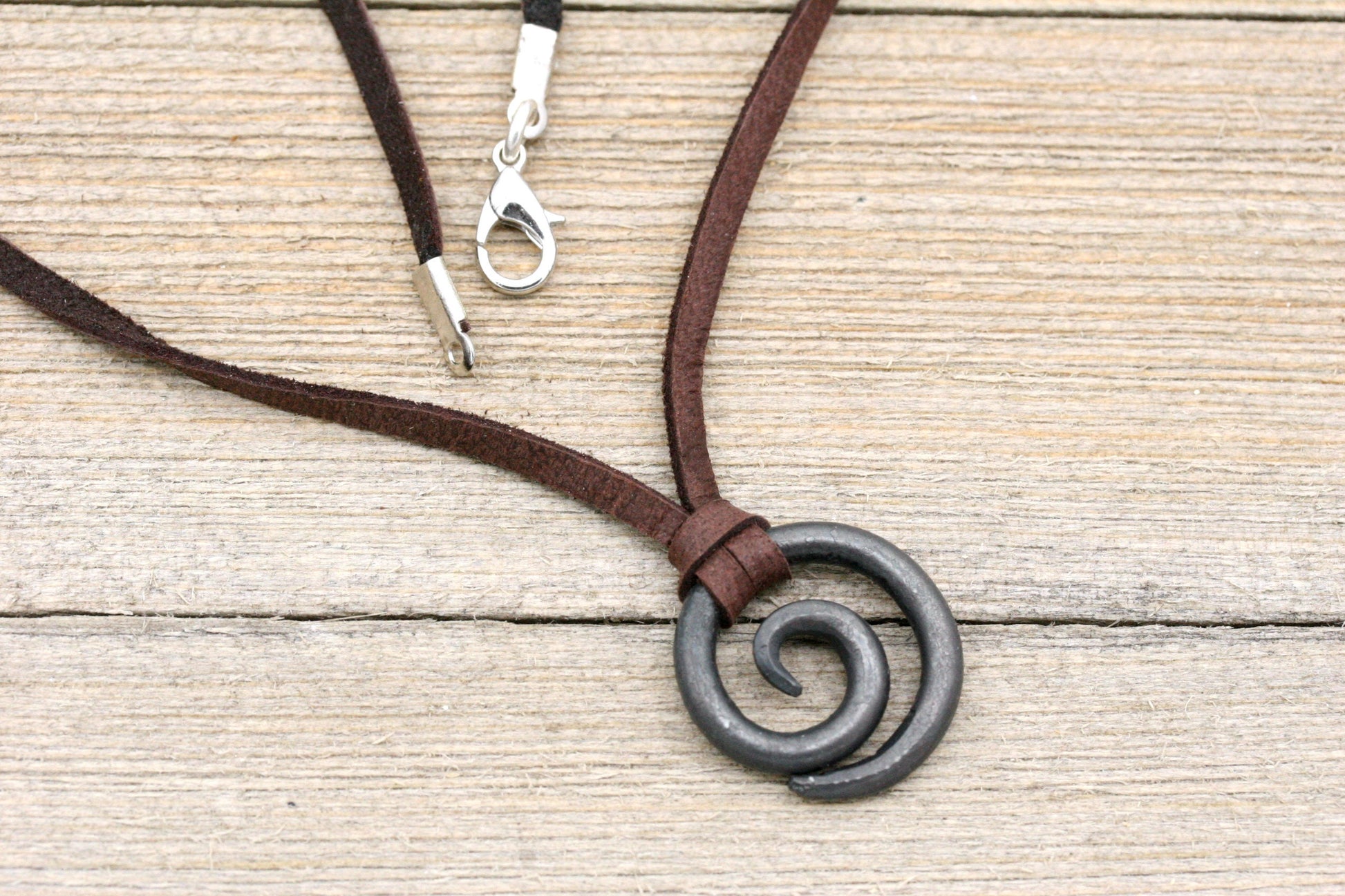 small iron spiral necklace held by dark brown deerskin lace. Great gift for men