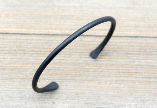 This bracelet is forged out of smooth, round, iron and is very lightweight.
Dramatic and sure to be noticed...each bracelet is handmade by me in a coal forge, shaped on the anvil, brushed, and finished with wax to prevent rusting and add shine.....a one of a kind piece of Art!