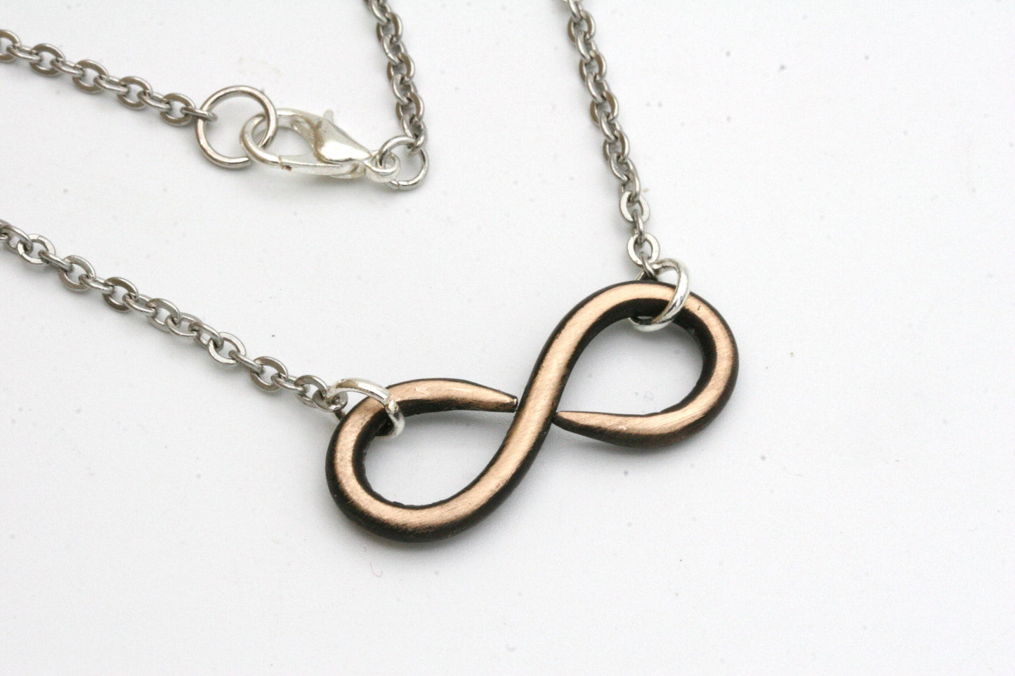 My hand forged infinity necklace is made from solid bronze and finished off with stainless steel chain that hooks with a lobster clasp.

You can choose from either 16, 18 or 20 inch necklace lengths during checkout.
The pendant measures approximately 1 1/4 inches across and 1/2 inch high.