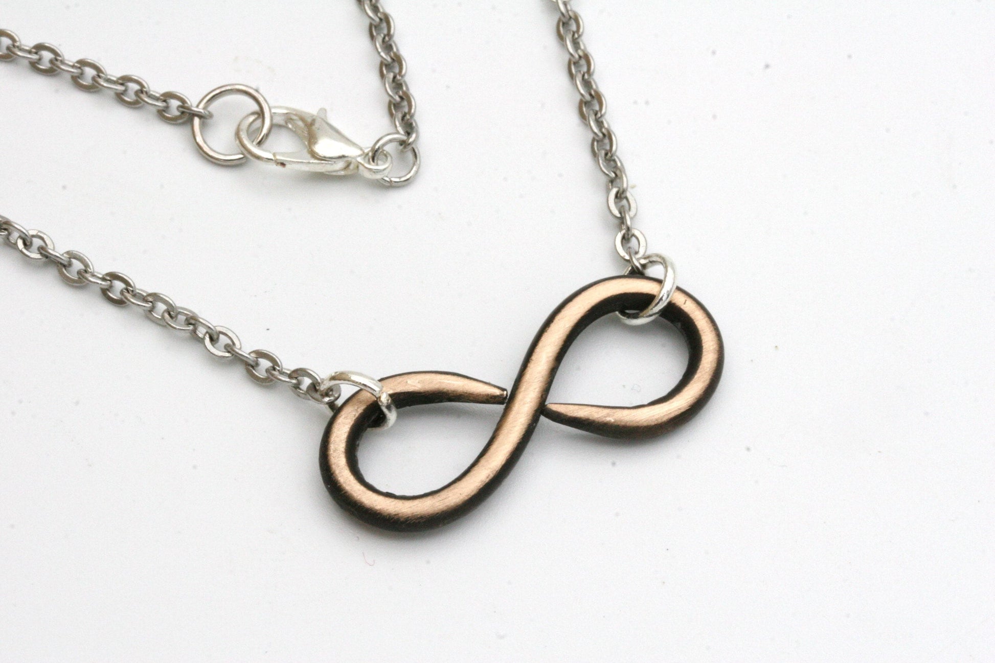 My hand forged infinity necklace is made from solid bronze and finished off with stainless steel chain that hooks with a lobster clasp.

You can choose from either 16, 18 or 20 inch necklace lengths during checkout.
The pendant measures approximately 1 1/4 inches across and 1/2 inch high.
