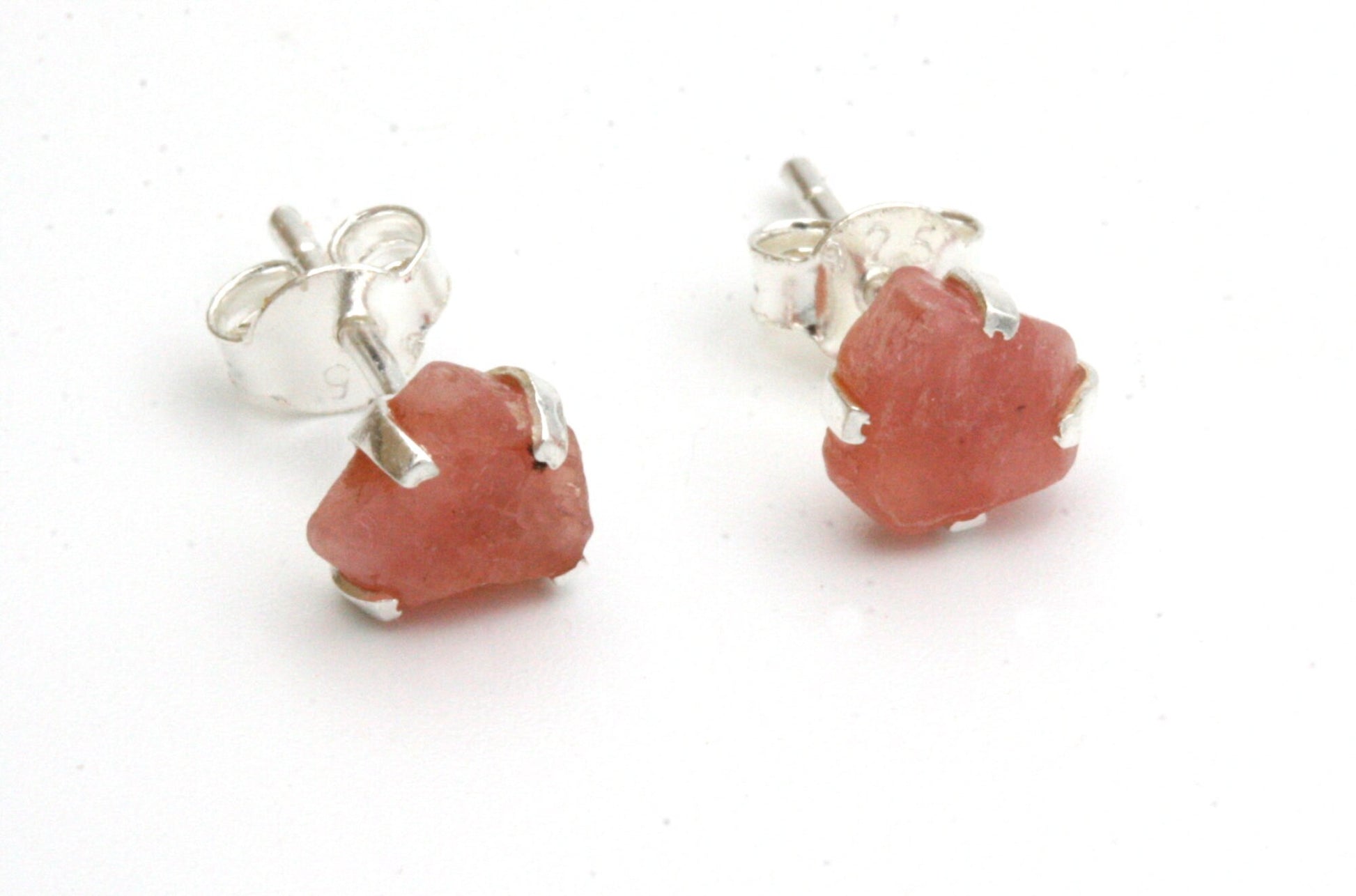 These spectacular Rhodochrosite stud earrings are rustic and beautiful! The Rhodochrosite is set in sterling silver claw settings to reveal the maximum amount of color.

The earrings come with sterling silver pierced ear posts and butterfly backs. The stones each measure approximately 6-7 mm in size - perfect for everyday wear.