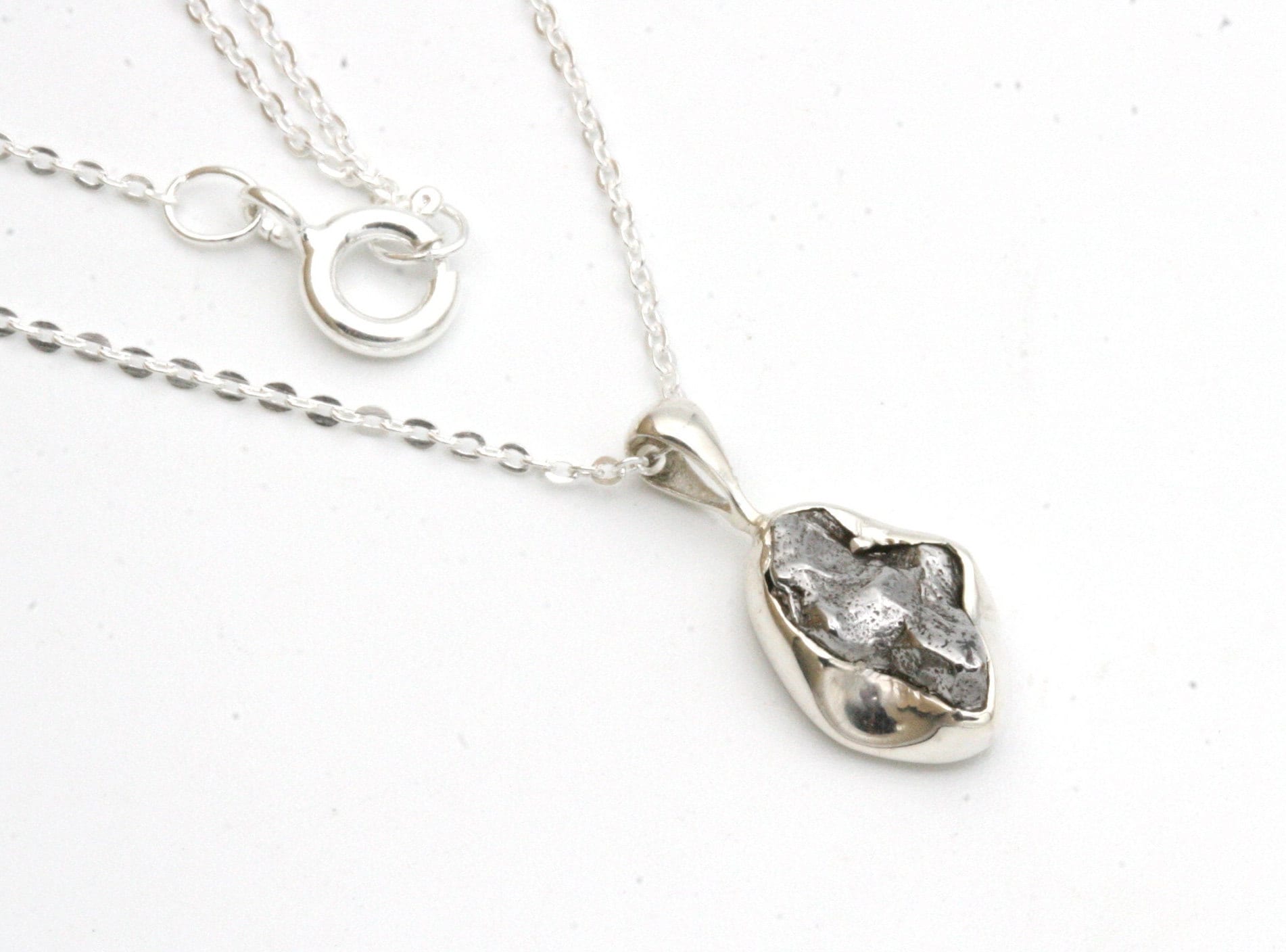 small meteorite pendant set in sterling silver and hung from a delicate sterling silver chain