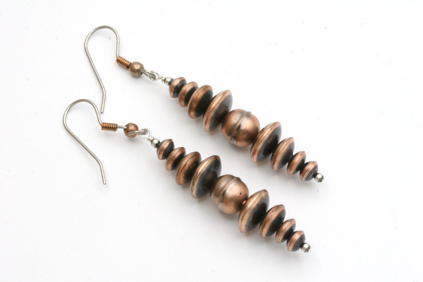 Southwestern Oxidized copper Earrings made with genuine Navajo pearls.

These beautiful earrings go great with jeans and a t-shirt or can be worn with a cute dress.
These are the real deal and not the 'faux' beads that are more cheaply priced.
These earrings are made with solid copper, oxidized round and saucer beads.
Each bead has a brushed satin finish.

The earrings measure 2.5" and are hung from sterling silver wires.