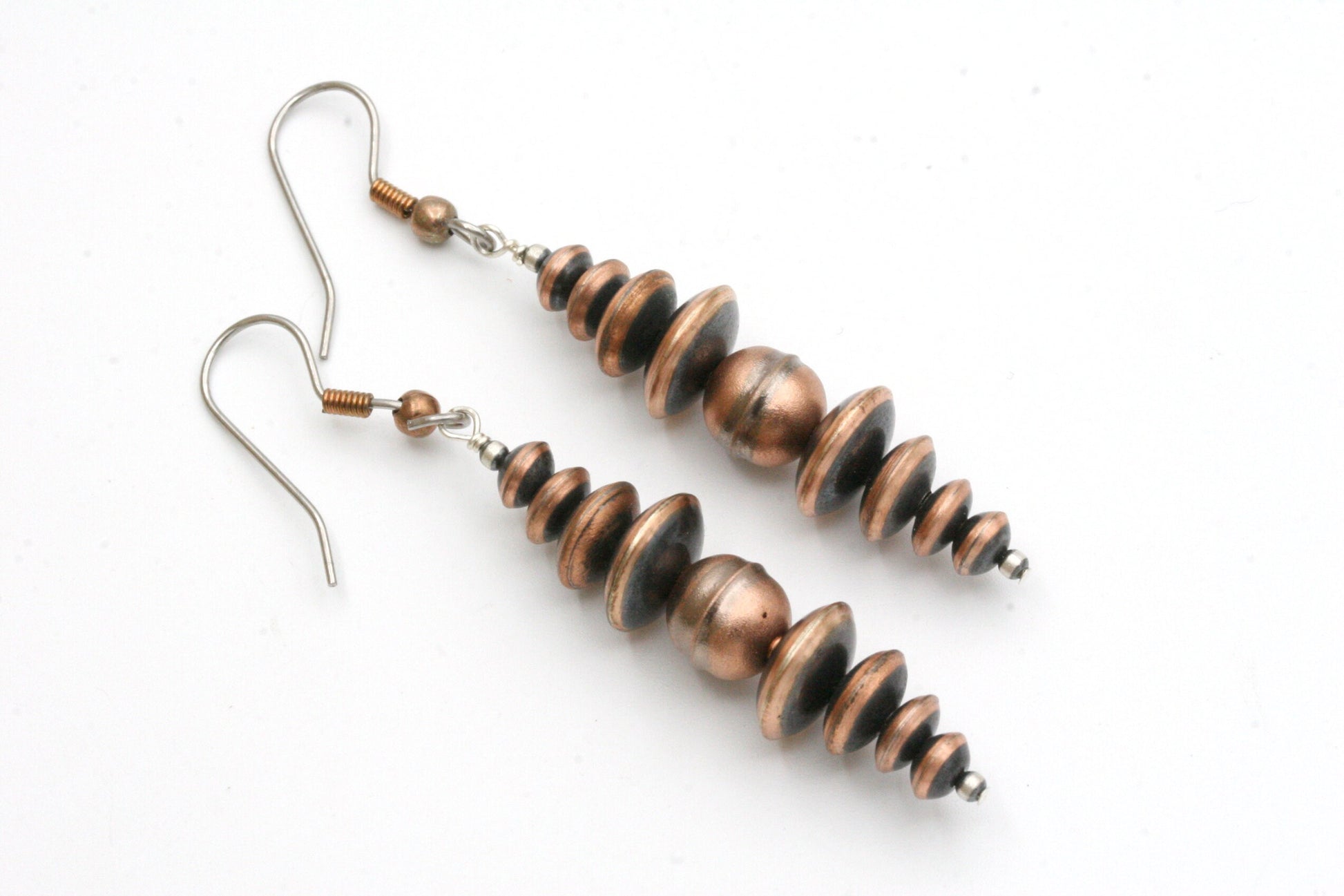 Southwestern Oxidized copper Earrings made with genuine Navajo pearls.

These beautiful earrings go great with jeans and a t-shirt or can be worn with a cute dress.
These are the real deal and not the 'faux' beads that are more cheaply priced.
These earrings are made with solid copper, oxidized round and saucer beads.
Each bead has a brushed satin finish.

The earrings measure 2.5" and are hung from sterling silver wires.