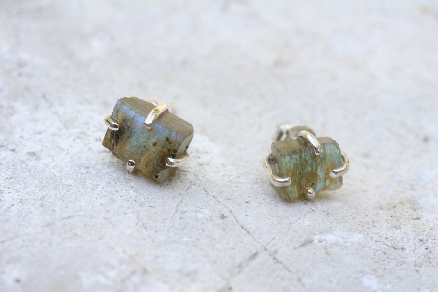 Spectacular Iridescent labradorite stones make up these stud earrings. These uncut stones are set in sterling silver claw settings to reveal the maximum amount of the natural gemstone.

The earrings come with sterling silver pierced ear posts and butterfly backs. The stones each measure approximately 5-6 mm in size - perfect for everyday wear.